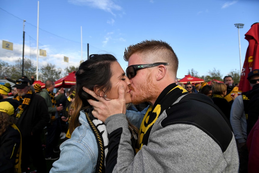 Fans kiss at the end of the game at the punt road live screening of the match