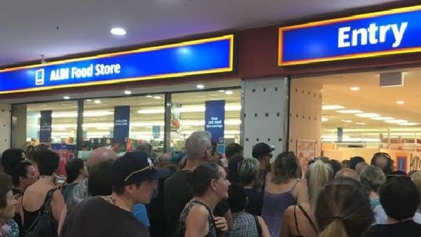 Shoppers queue outside an ALDI store
