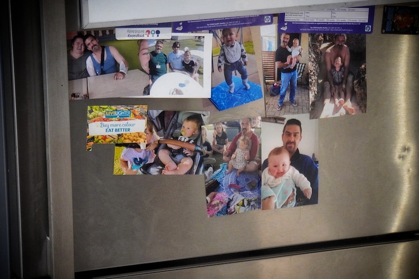 More than half a dozen family photos stuck to the door of a silver fridge.