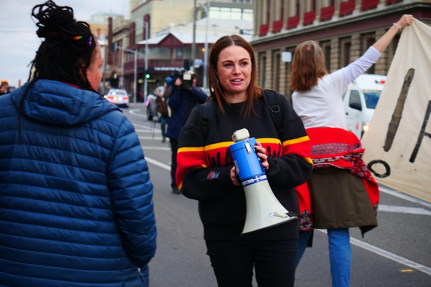 a woman holds a megaphone