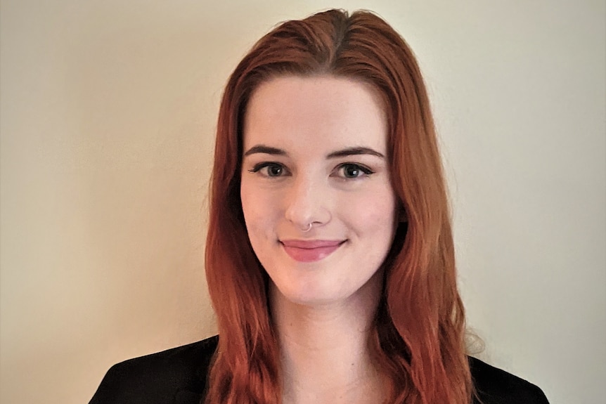 Headshot of red-haired woman smiling.