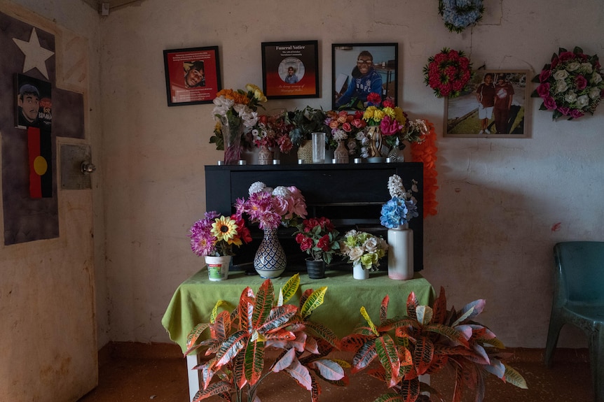 A shrine with vases of flowers and photos. 