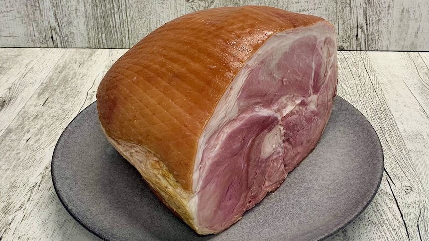 Cured leg of ham on a plate ready to be sliced