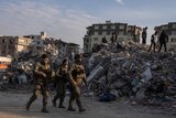 Turkish army patrols as rescue workers continue the search for victims atop rubble.