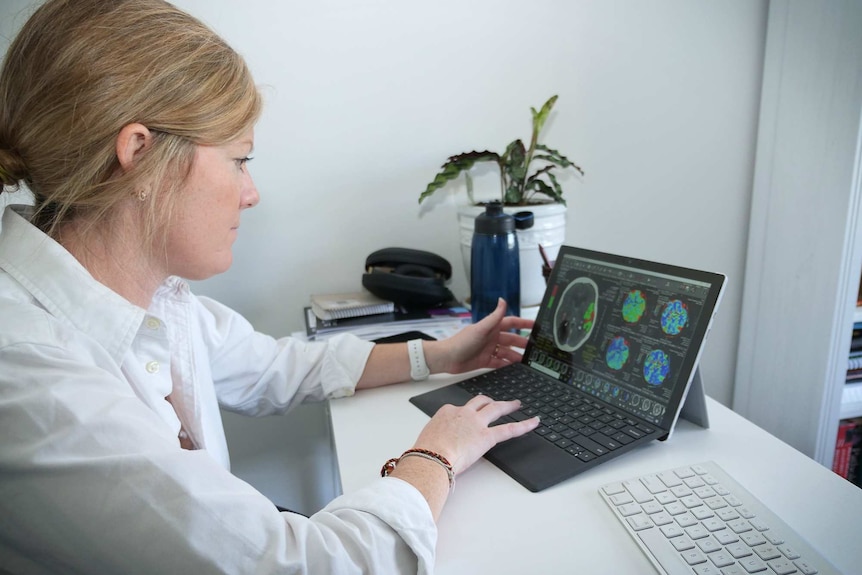 Angela looks at a brain scan on her laptop