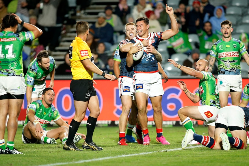 Adam Keighran hugs Joey Manu after a Sydney Roosters try against the Canberra Raiders.
