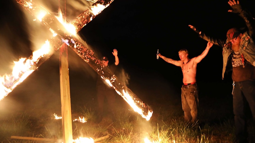 Members of the National Socialist Movement, a neo-Nazi group in the USA, holding a swastika burning in Georgia in April, 2018.