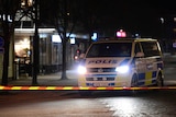 A Swedish police vehicle sits on a dark street