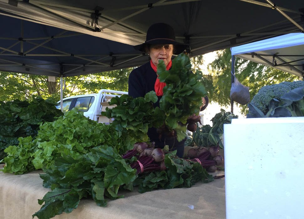 A market vendor organises her produce.