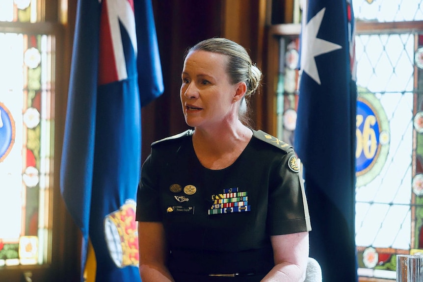 A woman wearing a defence uniform speaking.