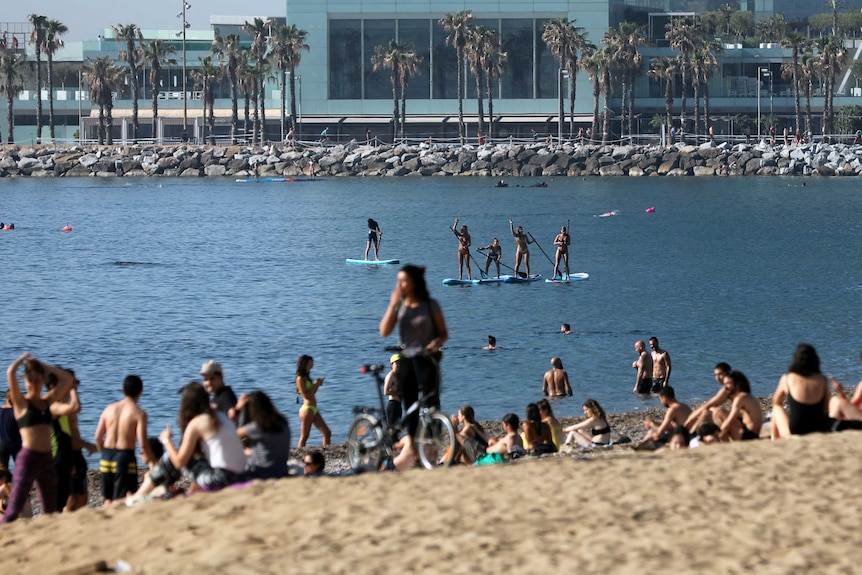 People practice paddle boarding at Barceloneta beach, amid the coronavirus disease (COVID-19) outbreak, in Barcelona.