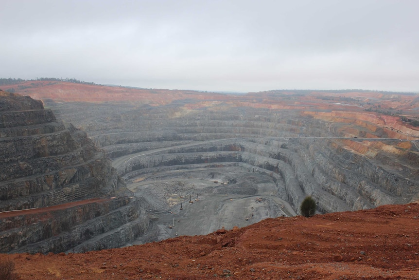 A photo of a large mine pit, hundreds of metres deep.