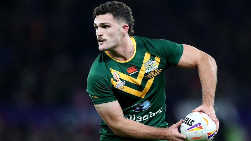 Nathan Cleary holds the ball in both hands as he plays for Australia at the 2022 men's Rugby League World Cup.