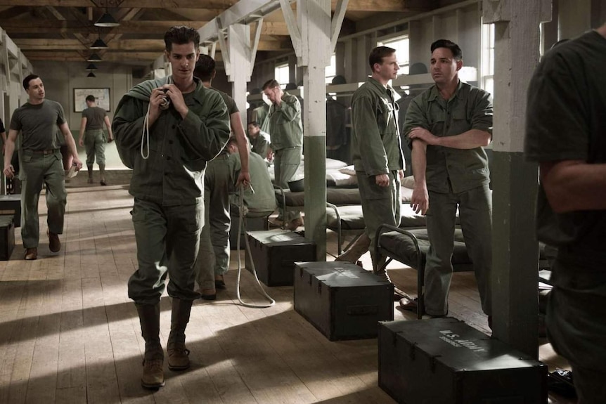 Andrew Garfield walks past his fellow soldiers in a scene from Hacksaw Ridge.