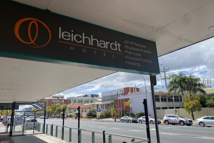 A hotel sign with the street in the background