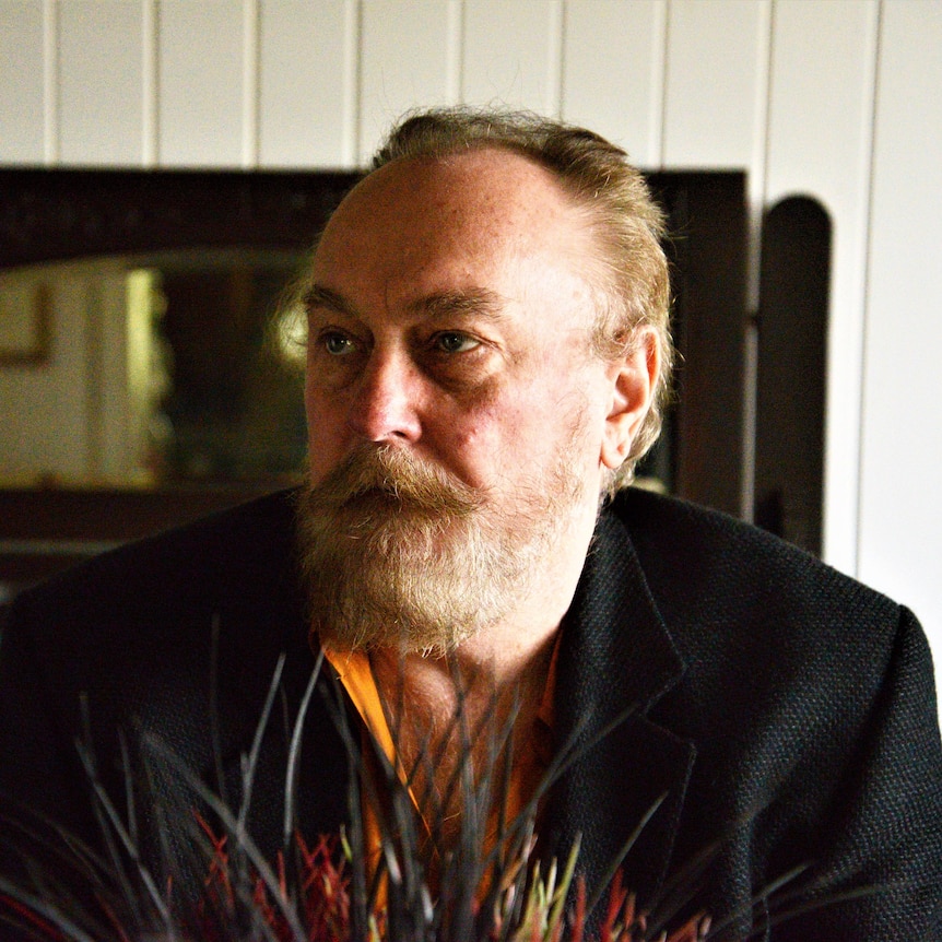 Ed Kuepper in a dapper suit, looking off-camera