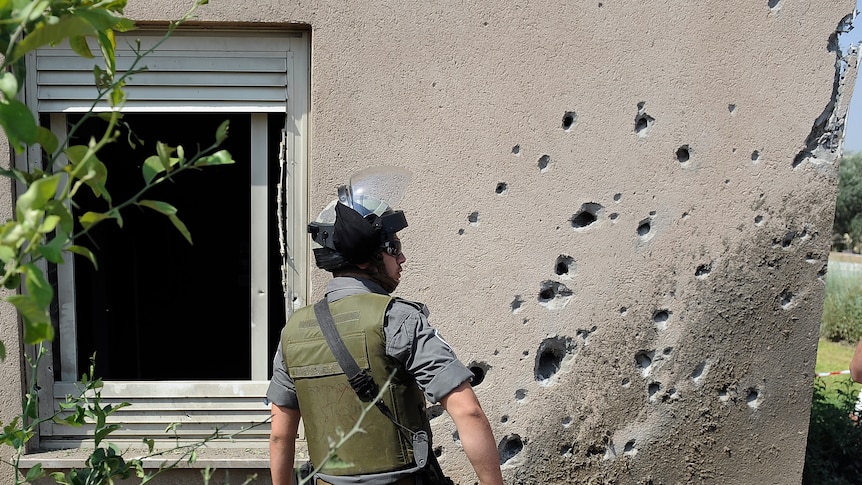 An Israeli border policeman surveys the damage caused by a rocket launched from the Palestinian Gaza Strip.