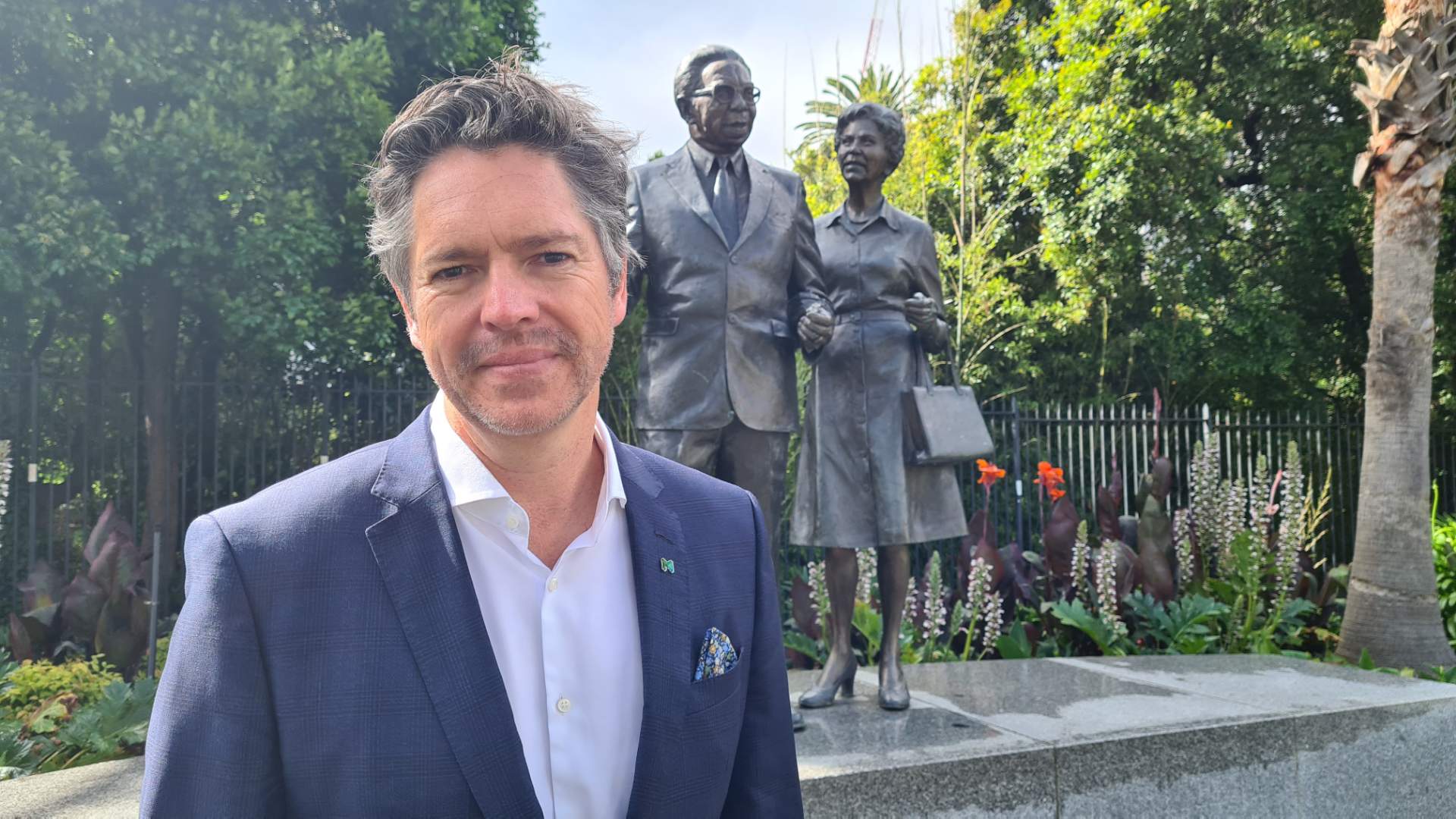 A man standing in front of a statue of a married couple