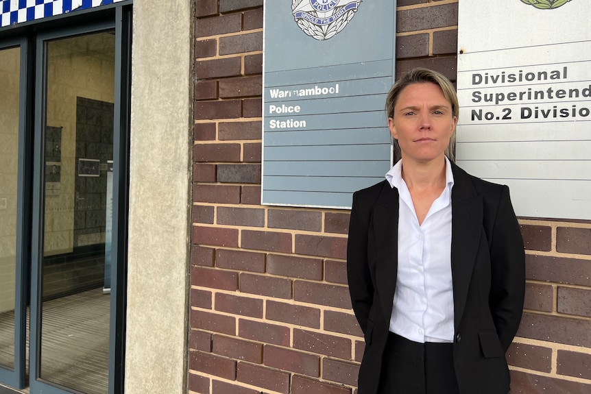 Policewoman poses outside station.