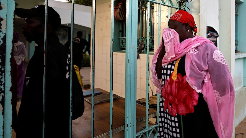 A grandmother cries as she waits outside a hospital in Senegal