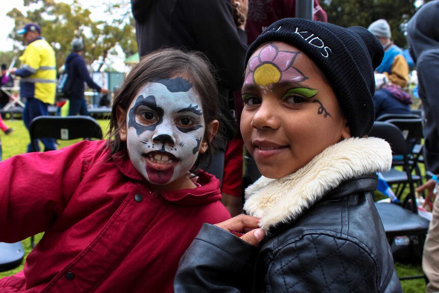 Two young Indigenous girls with face paint.