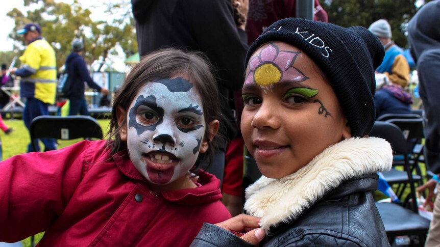 Two young Indigenous girls with face paint.