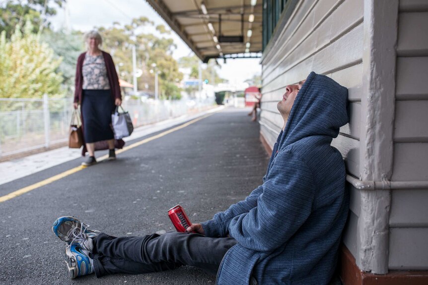 TJ Carpenter sits on the ground at Heidelberg train station.