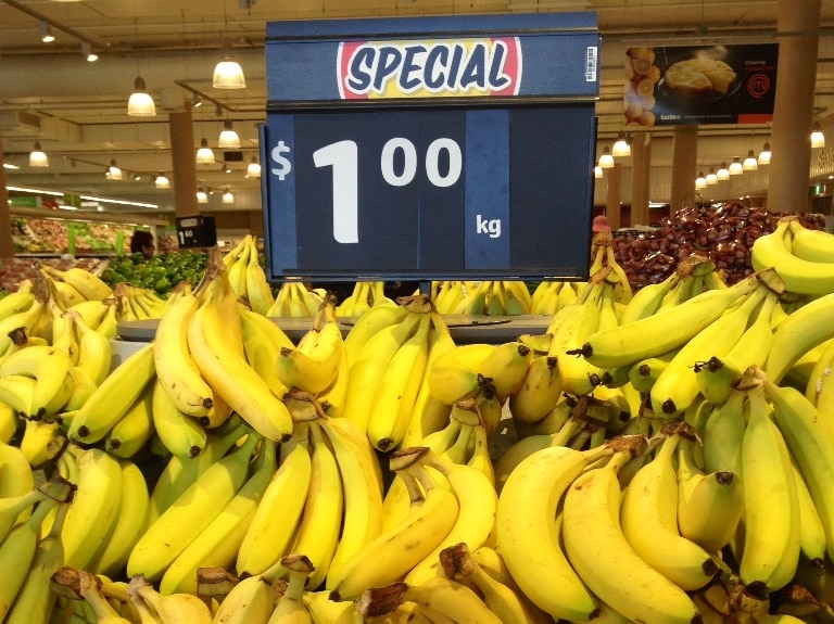 Bunches of bananas for sale on a stand in a supermarket.