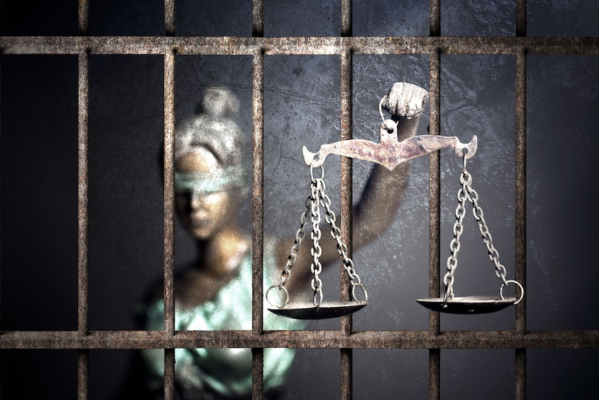Lady Justice holding scales inside a cell