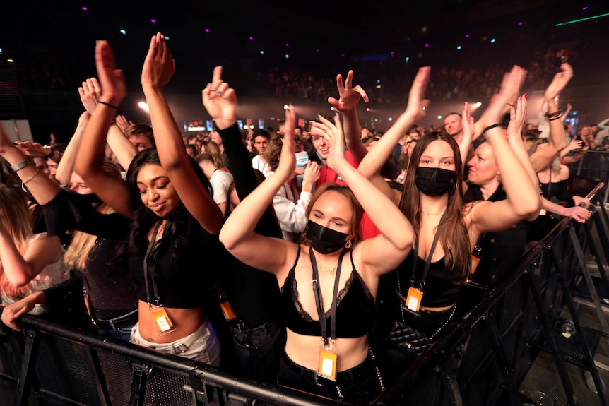 Young women dancing at a festival at night 