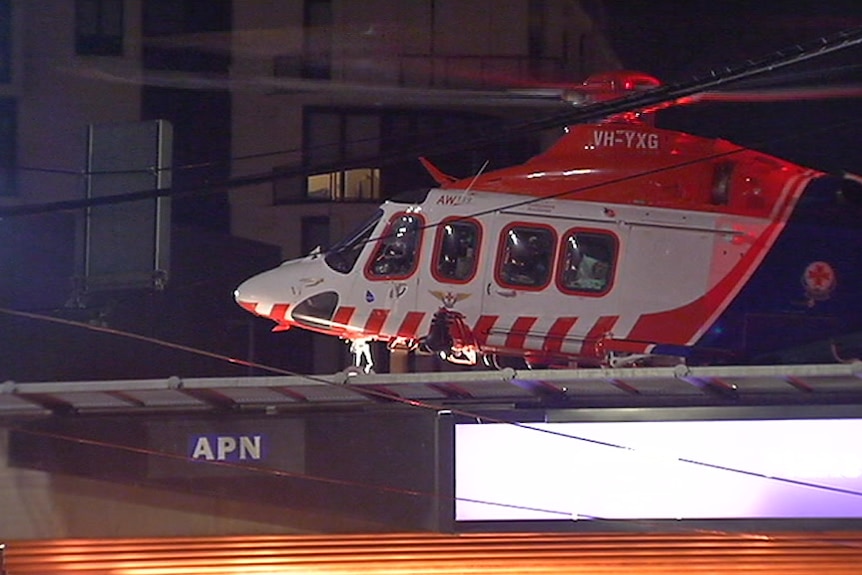 A helicopter lands on the Alfred Hospital helipad during the night.