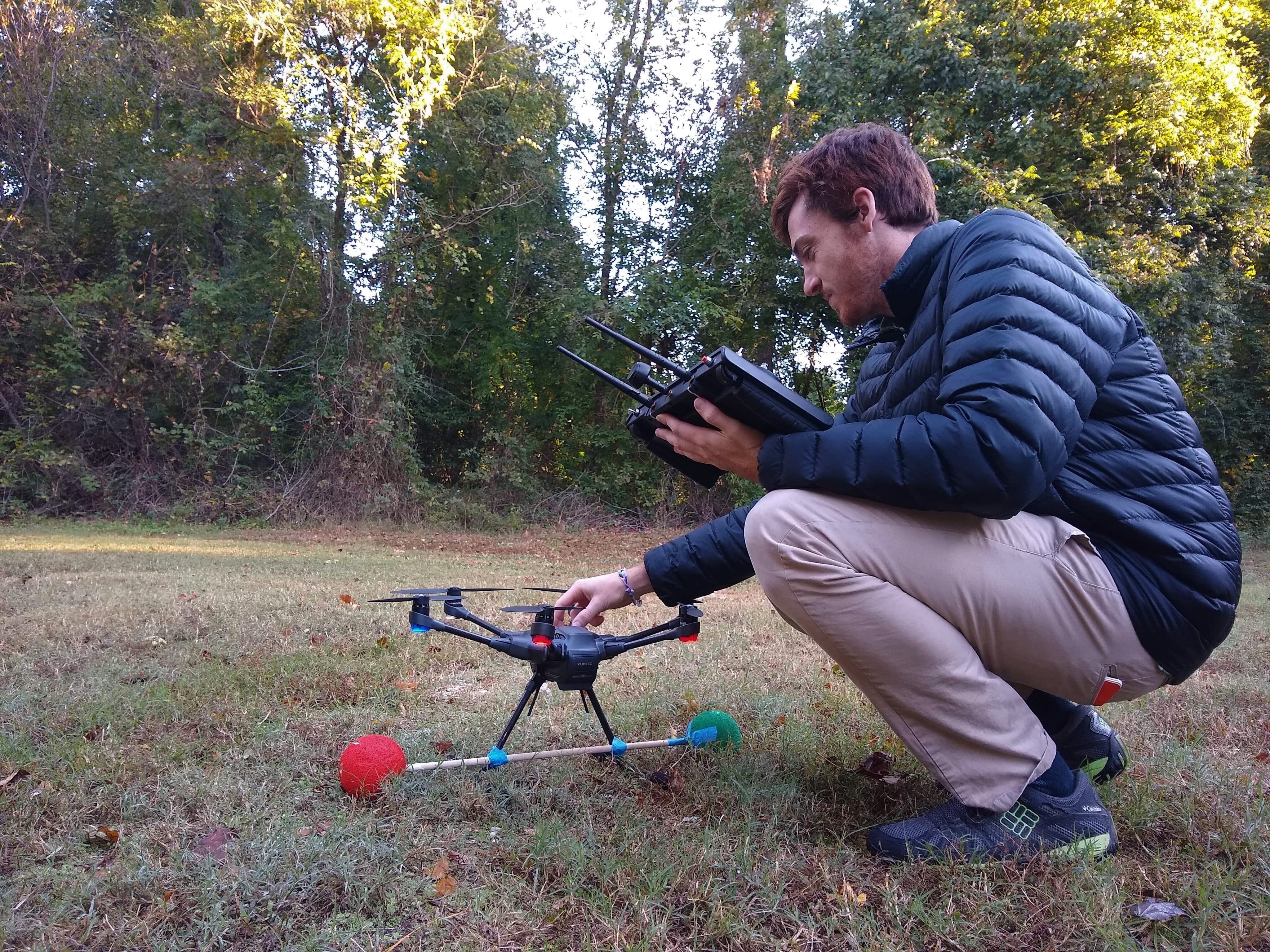 A scientist setting up a drone camera to track birds in flight