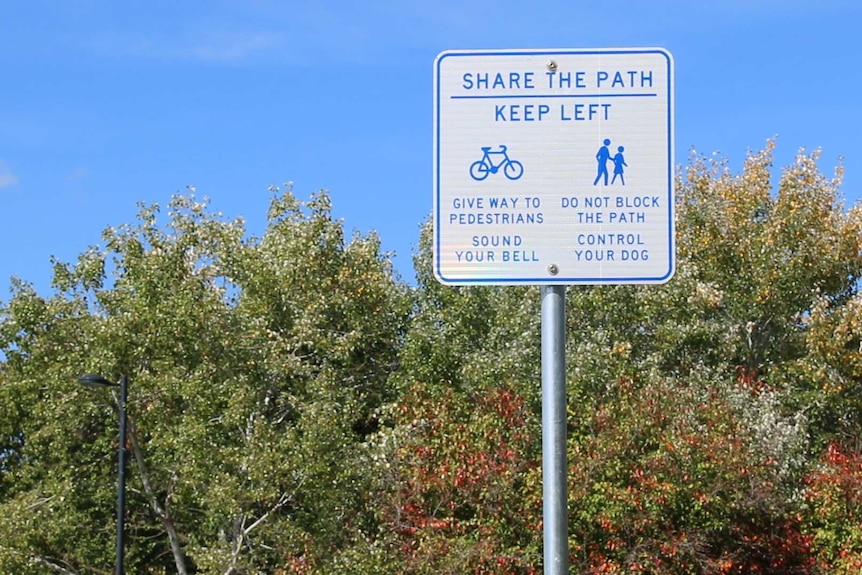 A sign near Lake Burley Griffins outlines road rules that apply to shared paths.