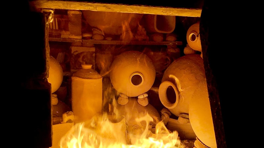 View through kiln opening to pots in intense red-hot fire.