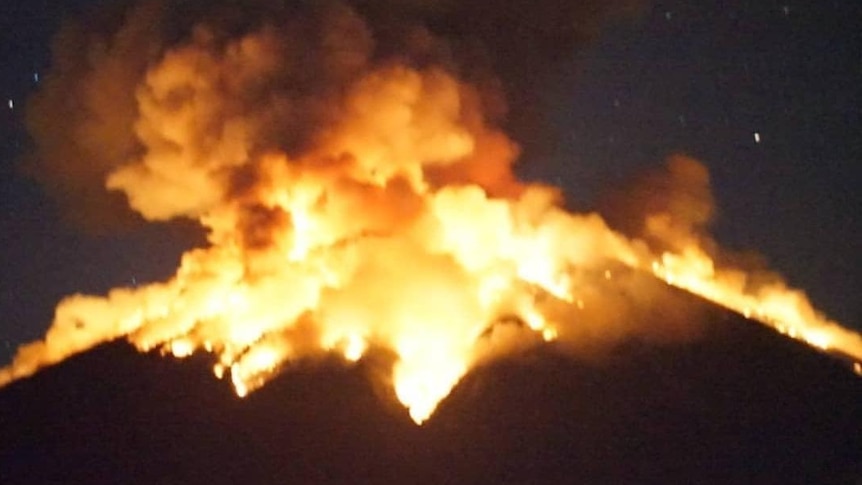 Mount Agung volcano erupts lava at night.