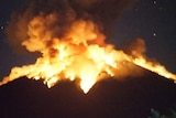 Mount Agung volcano erupts lava at night.