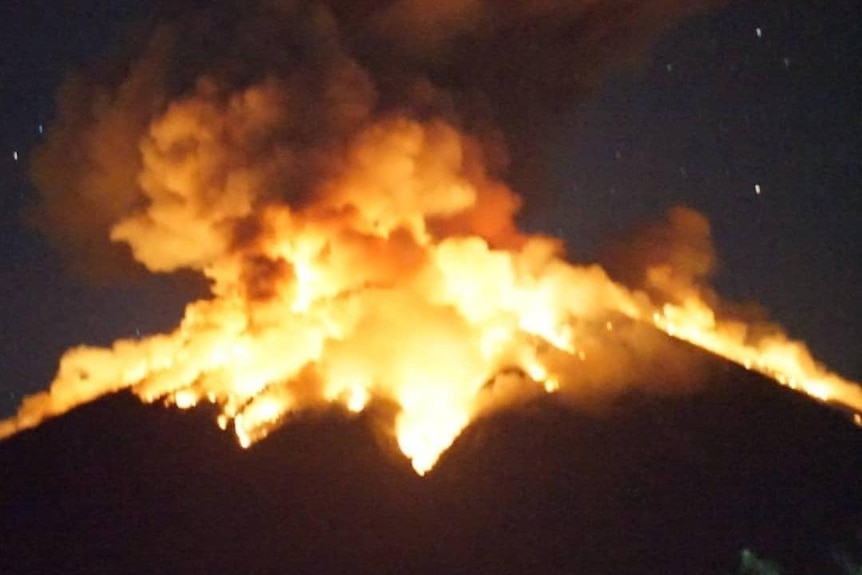 Mount Agung volcano erupts lava at night.