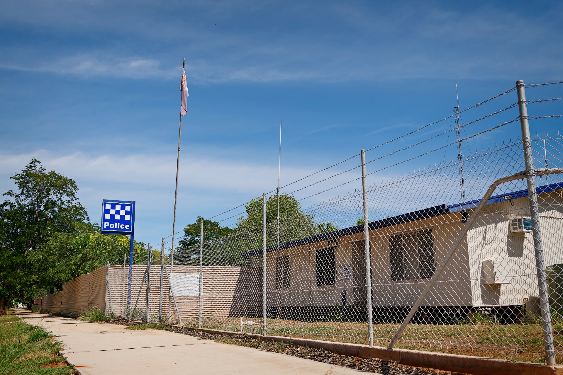 A small police station by the side of a road, on a sunny day.