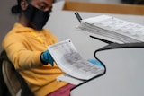 a county election worker scans mail-in ballots at a tabulating area at the Clark County Election Department in Las Vegas