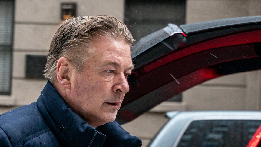 Alec Baldwin in a puffer jacket looking stressed. 