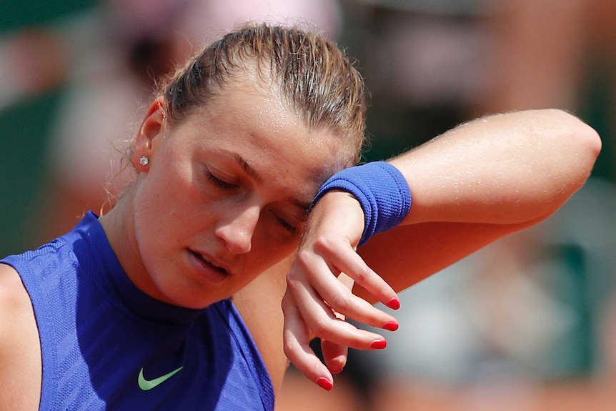 Petra Kvitova wipes away sweat while losing at the French Open