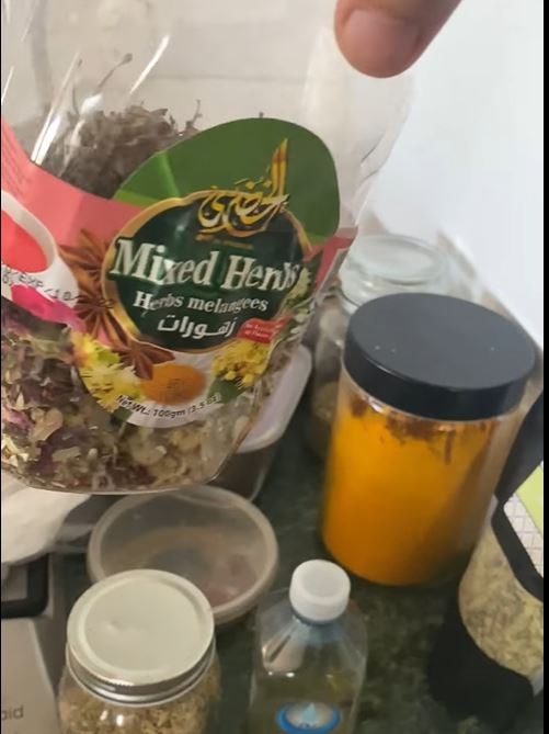 A bag of mixed herbs and jars in a kitchen 