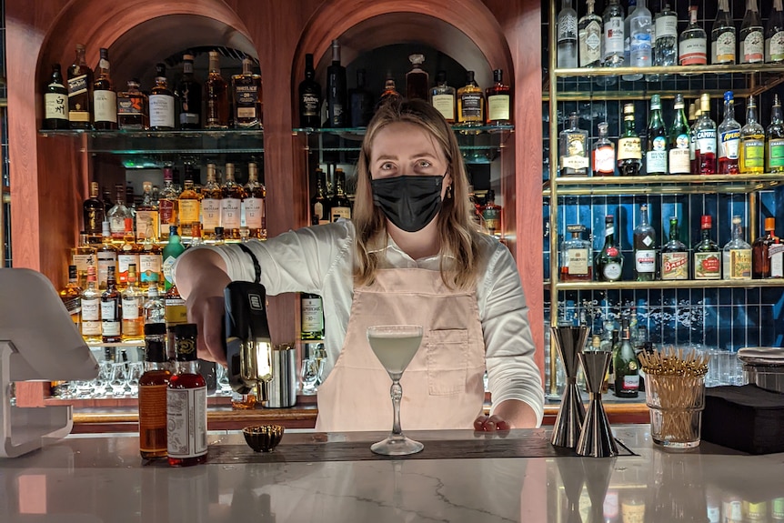 Anneliese Grazioli, owner of Darwin bar Hanky Panky Lounge, pours a cocktail at the bar. 