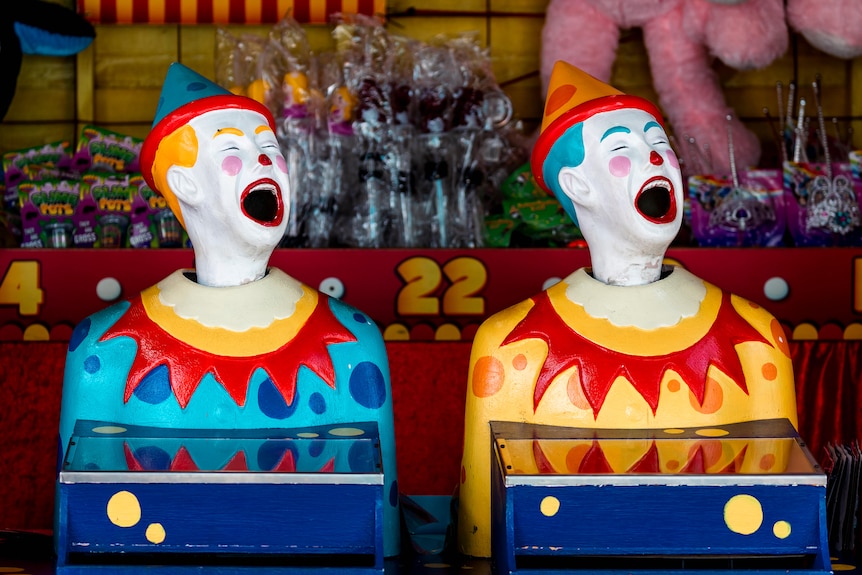 Clown heads in a fairground.