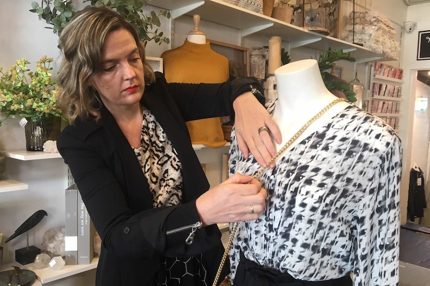 Amber Barnes arranges accessories on a mannequin in her retail boutique in Sydney's inner-west.