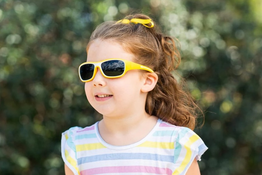 A girl wearing yellow sunglasses