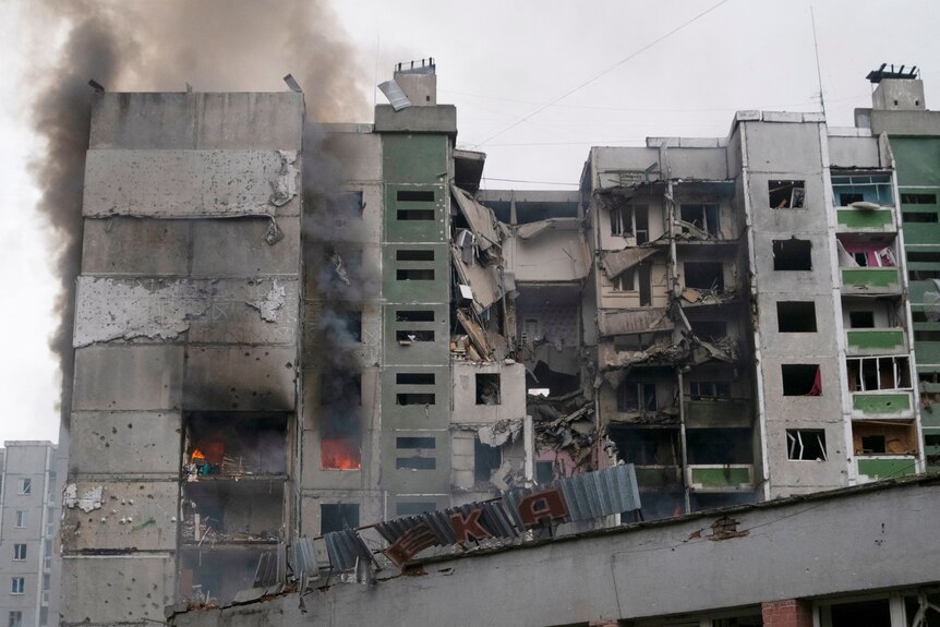 A view shows a residential building damaged by shelling