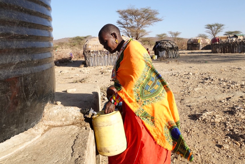 Margaret Lepeesha, one of the women of Unity, fills up a container of water from the village water tank.