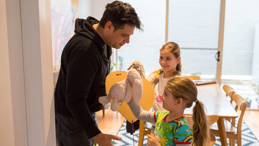 James plays with his daughters before school.