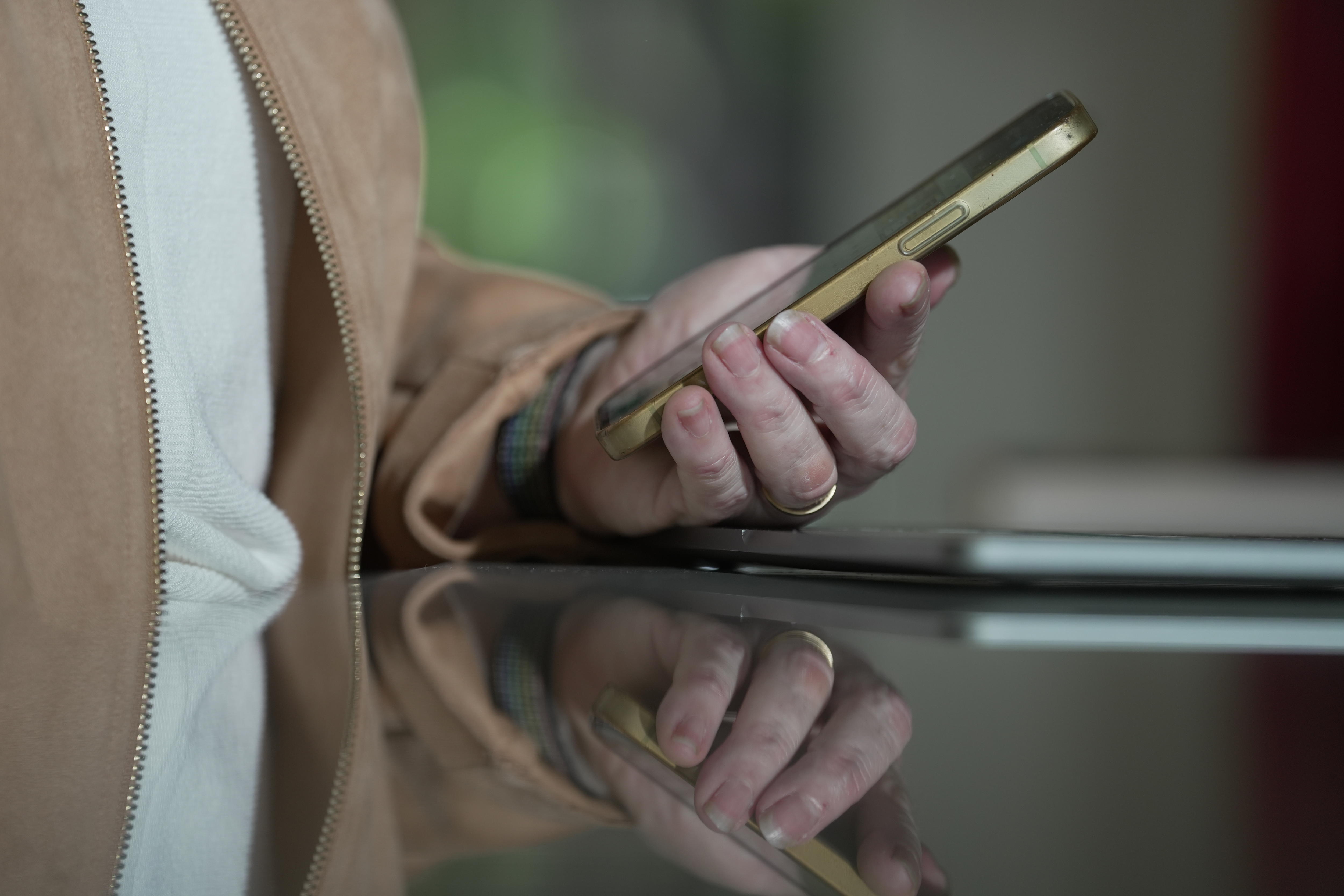 Um close de uma mão segurando um telefone celular.